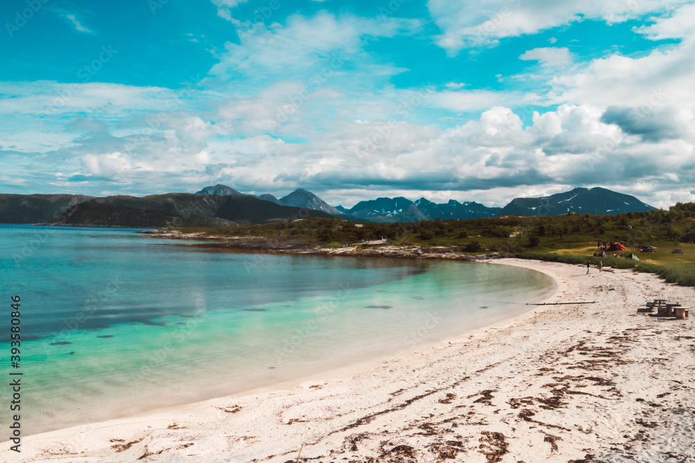 Scenic view of a white beach surrounded by mountains and turquoise ocean in Northern Norway