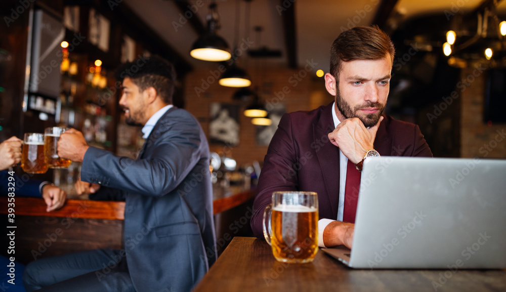 Handsome young business man, blogger or remote working with laptop in bar Handsome young business man, blogger or remote working with laptop in bar