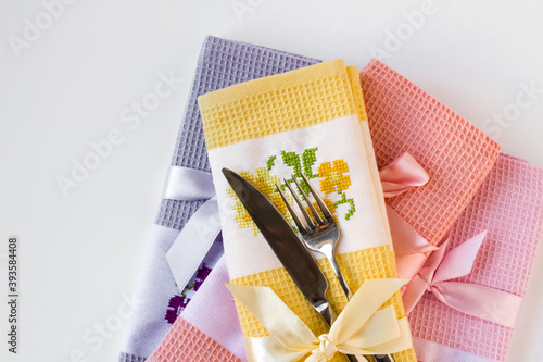 Special folded fabric napkins with cutlery set on white surface with copy space