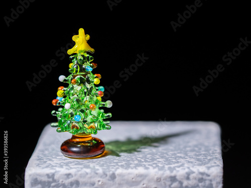 Tiny glass Christmas tree sitting on stone