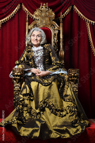 Portrait of beautiful senior woman Queen on throne