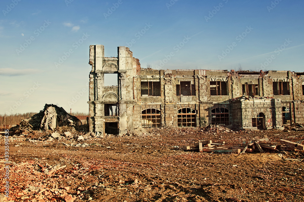 Landscape of ruined buildings at sunset, image of decrepitude or natural disaster.