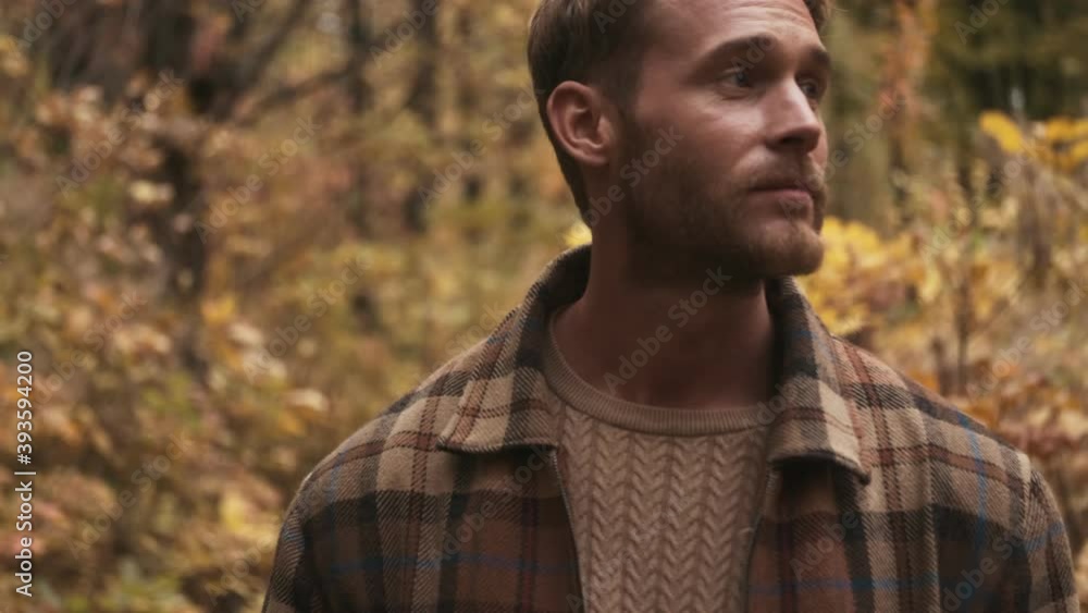 A positive blonde man is looking around walking in the autumn park A positive blonde man is looking around walking in the autumn park