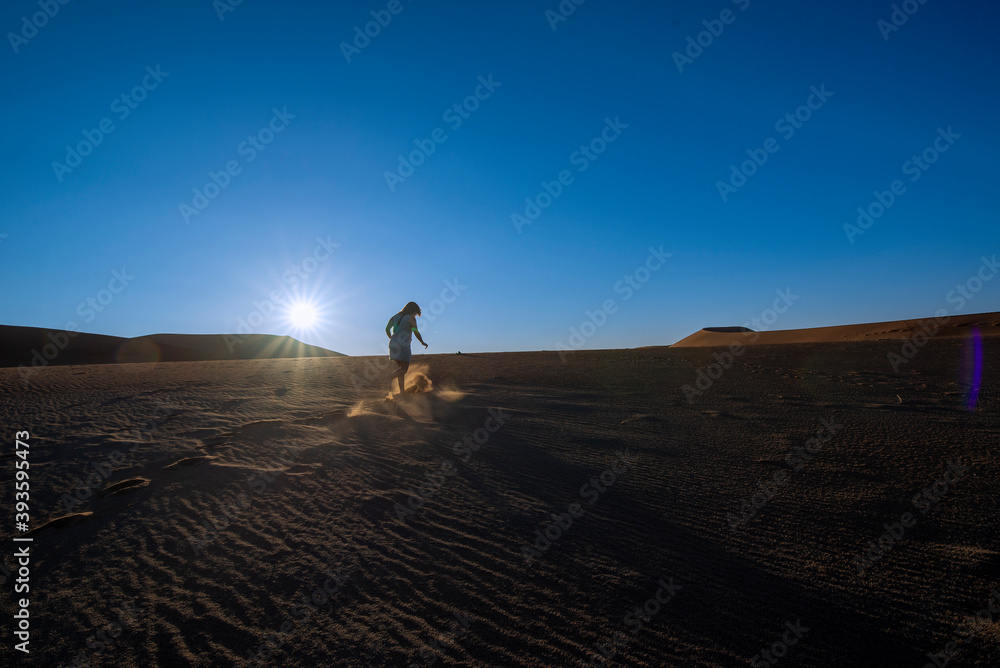 Person walking on dune in desert