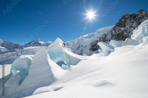 Man in red Ice climbing on The Tasman Glacier (Haupapa) which is the largest glacier in the Southern Alps, South Island, New Zealand.  photo