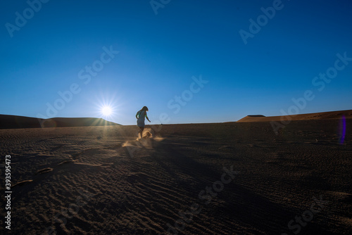 Person walking on dune in desert © Robin Weeks