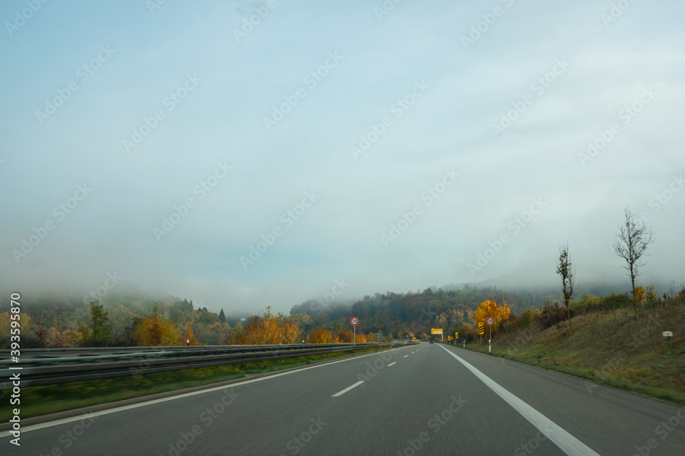 driving through the fog in colorful golden autumn forest in the morning driving through the fog in colorful golden autumn forest in the morning