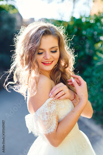 Portrait of a smiling tender bride on a background of green bushes, Beautiful backlight photo