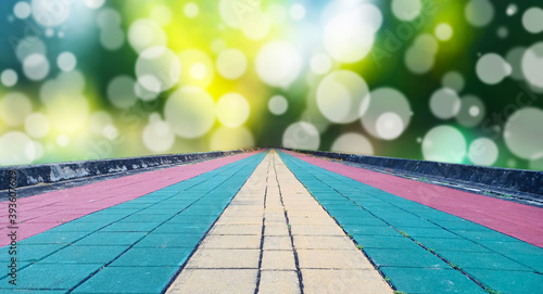 Colorful cobblestone bricks floor as pathway for jogging in the park with light spot bokeh as background. Goal concepts.