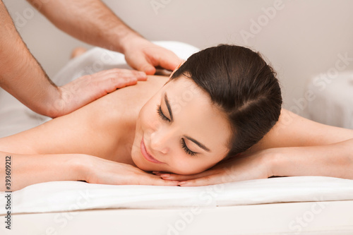 Thai back massage, mixed race woman during a relaxing massage. Anti-stress massage at wellness spa resort