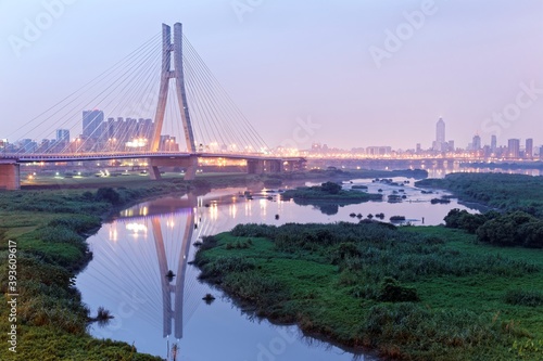 The bridge tower of New Taipei Bridge reflecting on the water under dramatic dawning sky before sunrise Landmark of Taipei, the New Taipei Expressway at dusk and in the twilight ( Low Angle View)