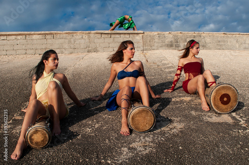 Photography Girls dressed in different colors with their faces painted posing with drums sit