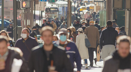 Crowd of people walking street wearing masks in New York City during Covid 19 coronavirus pandemic in 2020
