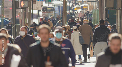 Crowd of people walking street wearing masks in New York City during Covid 19 coronavirus pandemic in 2020