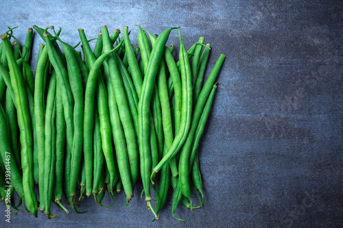 Green beans on grey stone background. Top view.