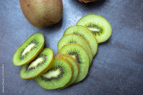 Whole ripe kiwi and half kiwi isolated on gray table, seen from above