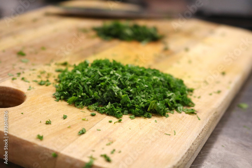 Finely chopped greens on a wooden board. A healthy fresh source of vitamins and minerals.
