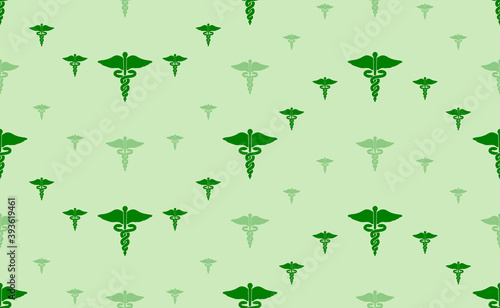 Seamless pattern of large and small green caduceus symbols. The elements are arranged in a wavy. Vector illustration on light green background