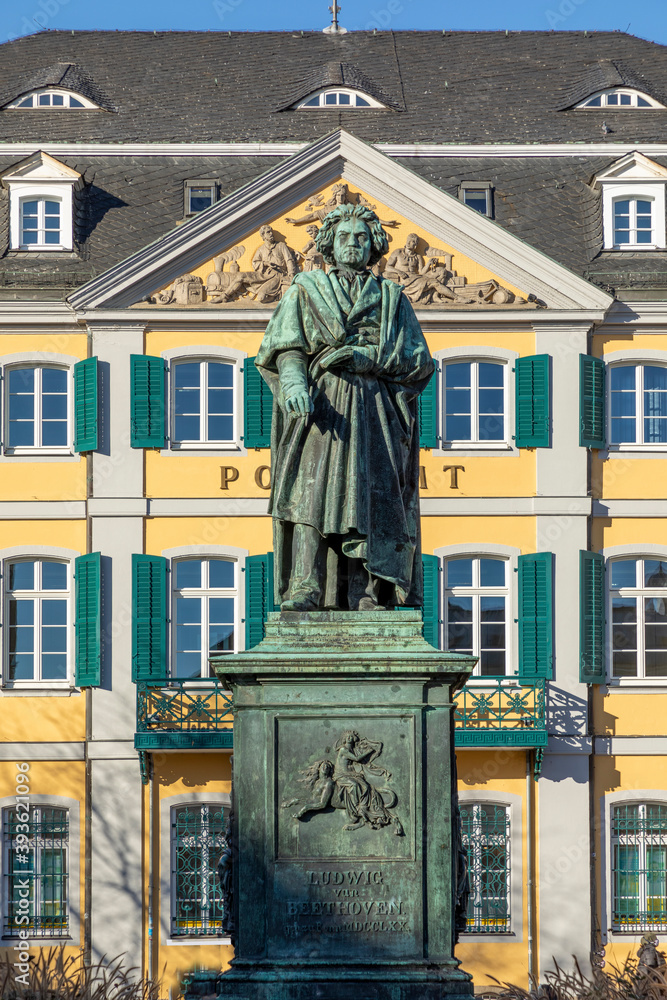 statue of famous composer Ludwig van Beethoven - with the beautiful Old Post Office building in the background, located on Munsterplatz in the city of Bonn in Germany.