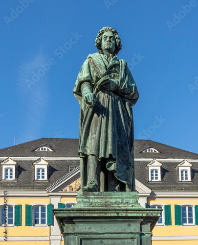 statue of famous composer Ludwig van Beethoven - with the beautiful Old Post Office building in the background, located on Munsterplatz in the city of Bonn in Germany.