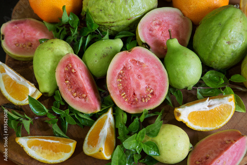 sliced and whole guava and tangerine fruits with Basil leaves