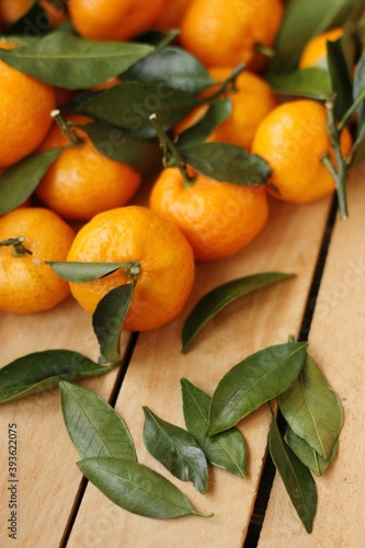 Juicy tangerines with green leaves in a wooden box 