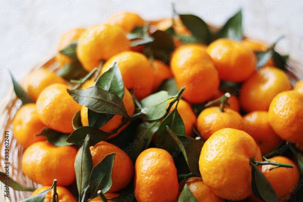 Juicy tangerines with green leaves on a wooden table Juicy tangerines with green leaves on a wooden table