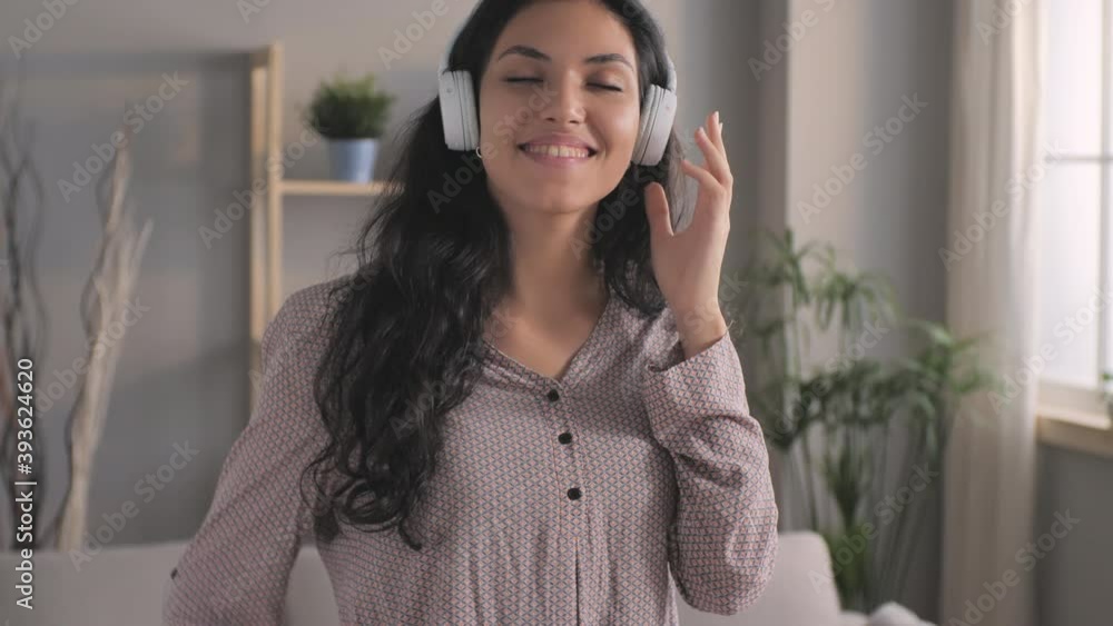 happy smiling arabian girl having fun dancing alone at home,carefree middle eastern young woman with headset listen to music dance in living room enjoy song playing in app happy smiling arabian girl having fun dancing alone at home,carefree middle eastern young woman with headset listen to music dance in living room enjoy song playing in app