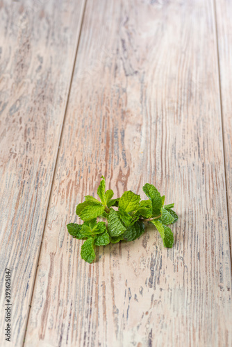 fresh green mint leaves on wooden background, close view 
