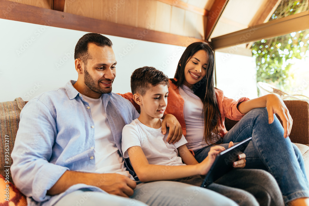 Parents and son using tablet on sofa at home Parents and son using tablet on sofa at home