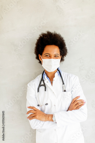 Female African American doctor wear white uniform and protective facial mask