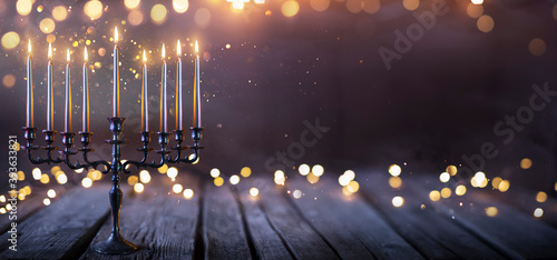 Hanukkah Abstract Defocused Background - Menorah With Bright Dust On Wooden Table photo