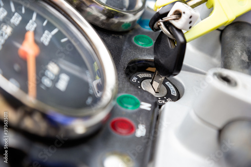 Close up of ignition switch with key and speedometer on motorcycle