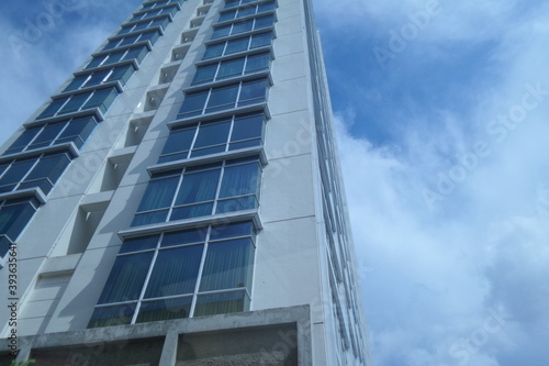 Edge of modern apartment tower with glassy design and cloudy sky