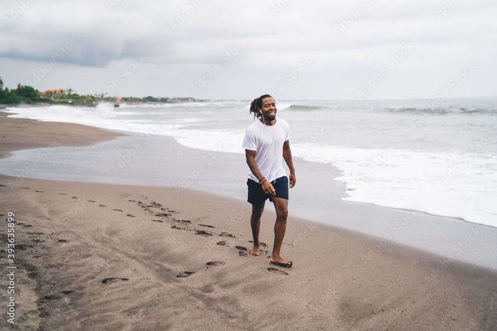 African American male walking on shoreline
