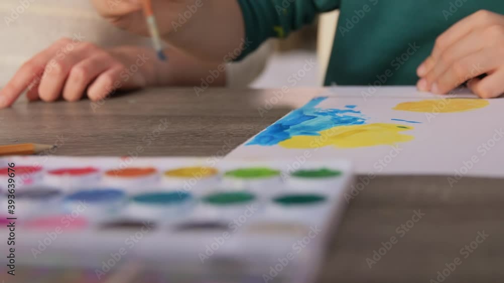 family, leisure and people concept - mother and little son with colors and paper drawing at home family, leisure and people concept - mother and little son with colors and paper drawing at home