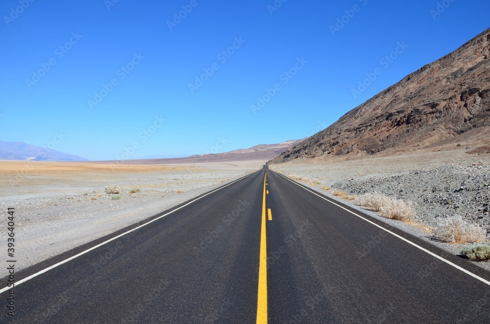 Highway 190 near Badwater Basin in Death Valley, California, blue sky background Highway 190 near Badwater Basin in Death Valley, California, blue sky background