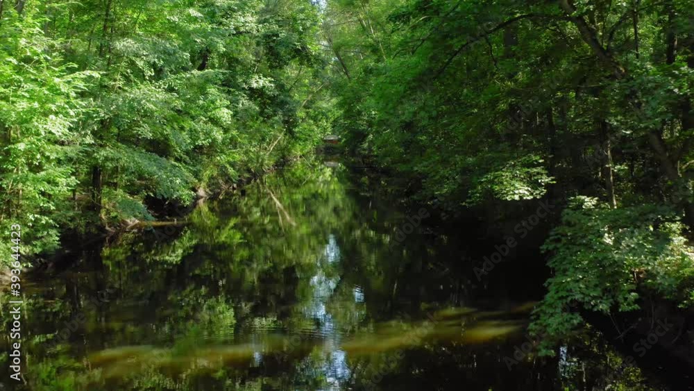 Slowly flying over beautiful river between banks covered with green trees, drone moving forward Slowly flying over beautiful river between banks covered with green trees, drone moving forward