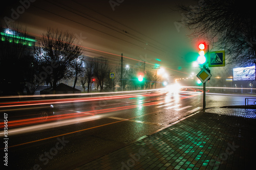 the night city beautifully shines with the lights of traffic lights and passing cars