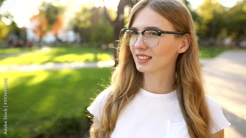 Young beautiful happy woman in glasses smiling outdoors in the park Young beautiful happy woman in glasses smiling outdoors in the park