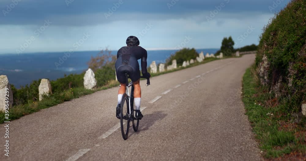 Professional cyclist riding bike on a mountain road Professional cyclist riding bike on a mountain road