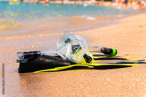 Snorkeling equipment set snorkel mask fins lie on golden sand by the seashore