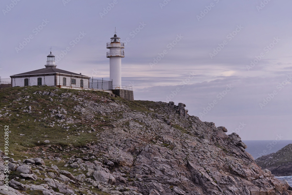 Touriñan Lighthouse in Muxia, Galician coast, Spain. Twice a year, at the beginning of spring and the end of summer, Cape Touriñan becomes the last shadow for the sunset in continental Europe.