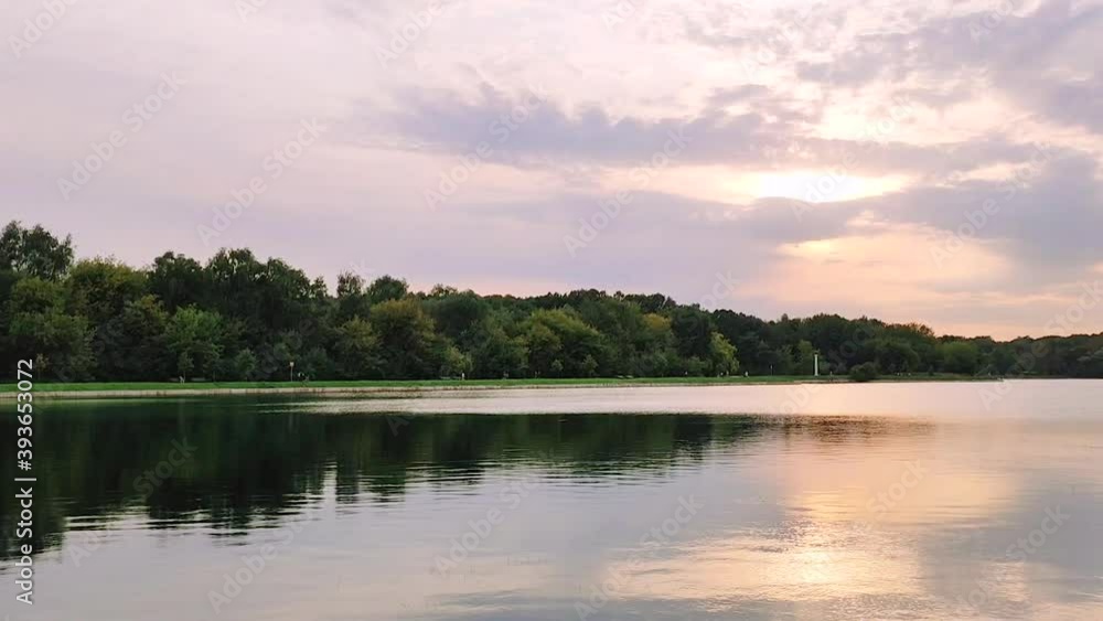 View of a beautiful sunset from the embankment on the lake in the park. View of a beautiful sunset from the embankment on the lake in the park.