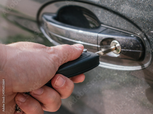 Detail of a woman's hand opening a car door with the key