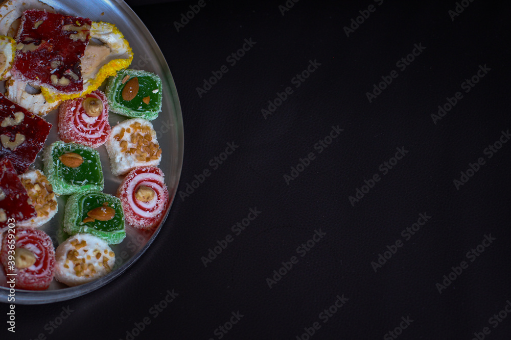 Oriental sweets in a round metal tray on a dark background