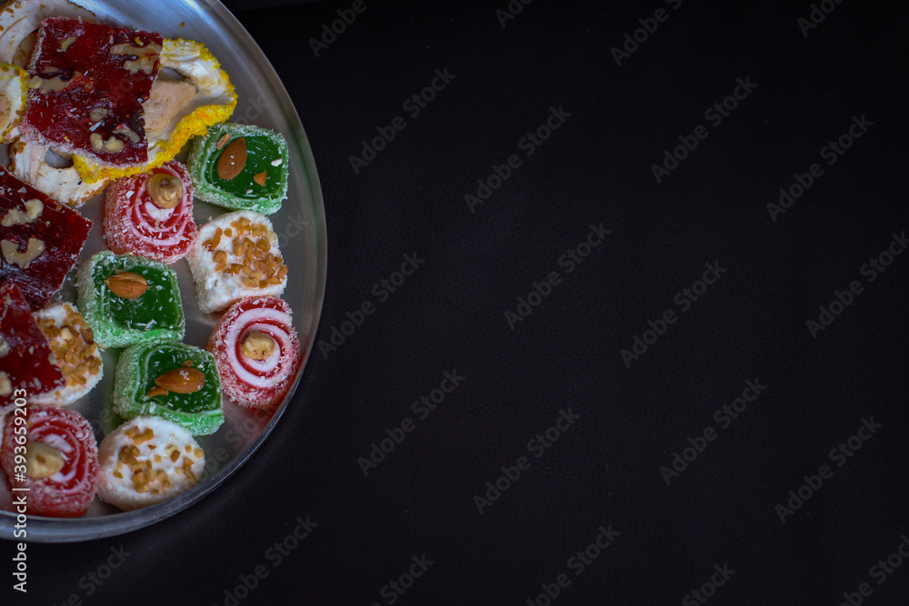 Oriental sweets in a round metal tray on a dark background Oriental sweets in a round metal tray on a dark background