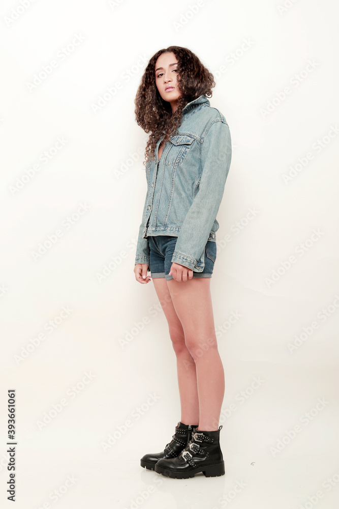 chica morena cuerpo entero de pi vestida con ropa de denim y botas sobre fondo blanco