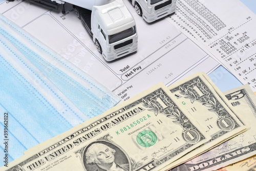 A lorry toys, payroll with dollar bill and face mask