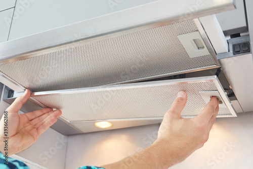 Tableau sur toile Mans hands removing a filter from cooker hood for cleaning or service